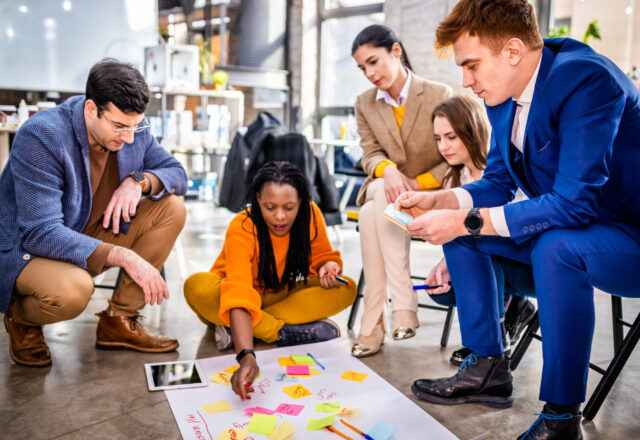 Project managers and employees brainstorming on ideas - Multi-ethnic group of workers having business meeting in a start-up office